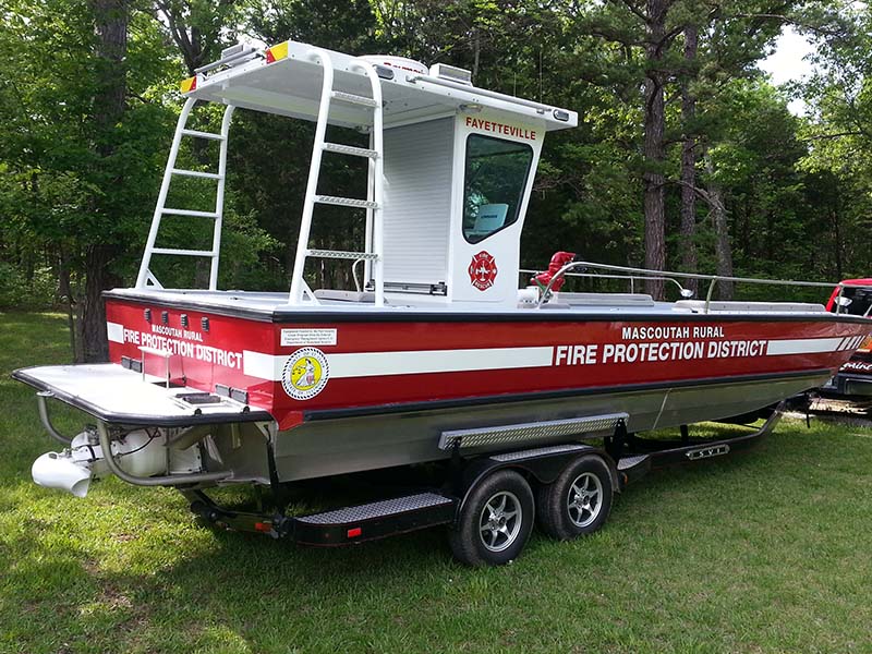 fire protection district boat on a trailer in a field