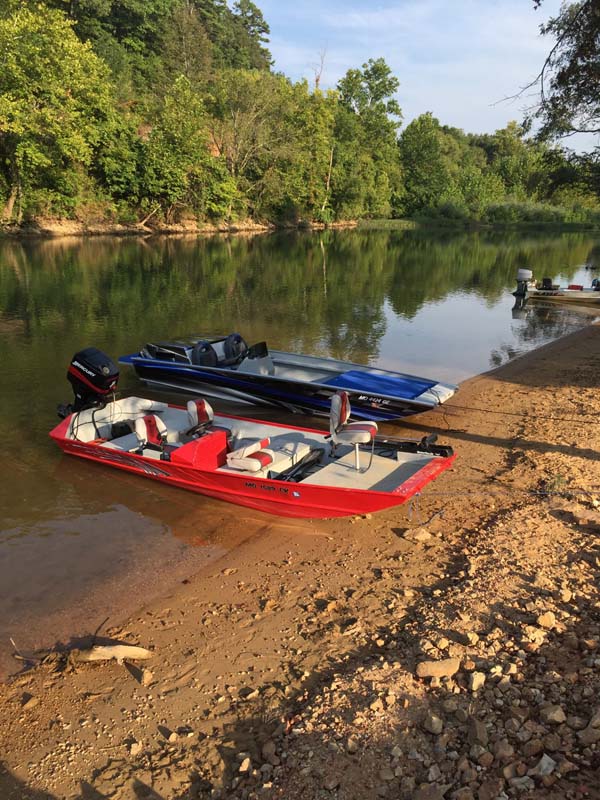three boats lined up on gravel bar