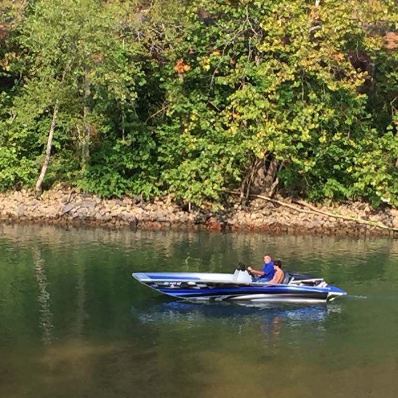two people driving a blue boat