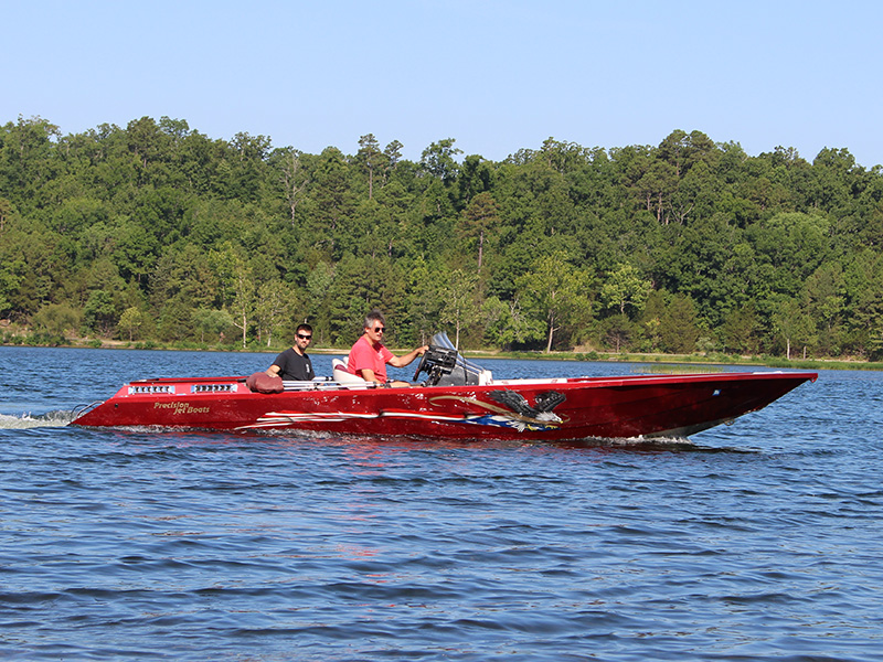 red speedboat idling on a lake