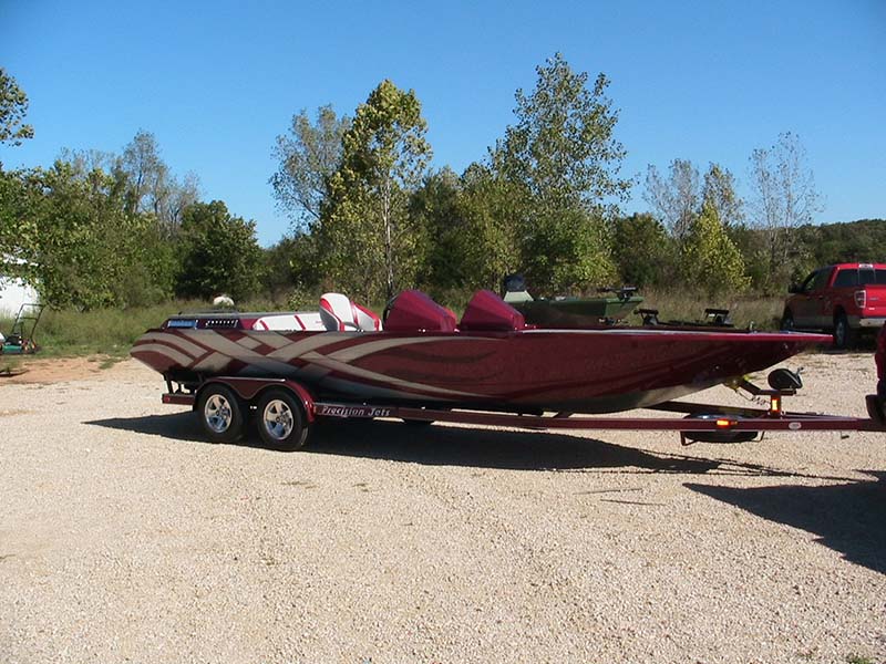 burgundy and gray boat on a trailer