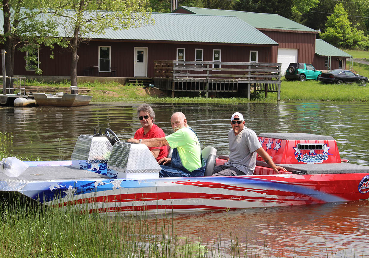 three men in a red, white, and blue boat